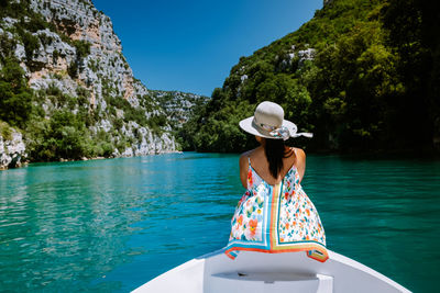 Rear view of woman in boat against sea