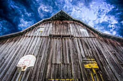 Low angle view of abandoned barn against sky