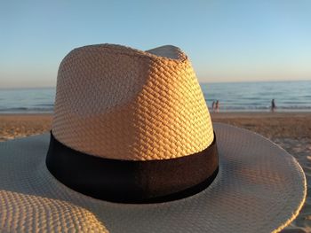 Close-up of hat on beach against sky