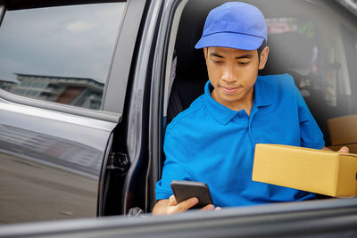 Delivery person using mobile phone in car