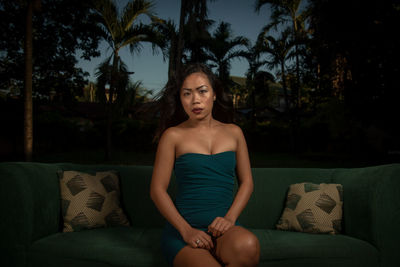 Portrait of young woman sitting on sofa