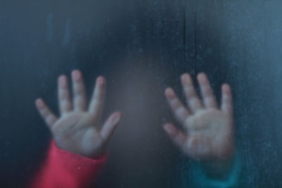 Close-up of hands of a child pressed against a glass door. frosted glass. 