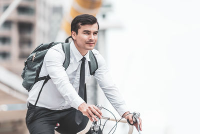 Young man with bicycle in background