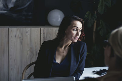 Businesswoman discussing with colleague in home office