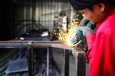 Welder used grinding stone on steel in factory with sparks, welding process at the industrial work