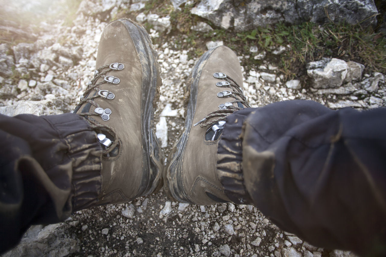 low section, shoe, human leg, personal perspective, nature, spring, lifestyles, winter, one person, day, leisure activity, footwear, men, limb, outdoors, human limb, land, rock, human foot, standing, adult, close-up, walking shoe, high angle view, snow