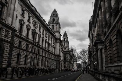 Road amidst buildings against sky at dusk