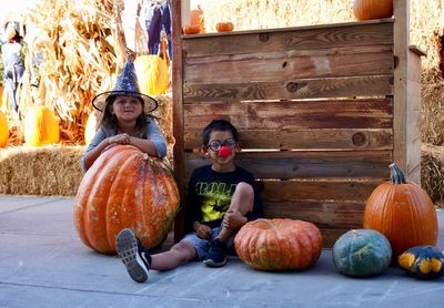 Portrait of woman sitting on pumpkin