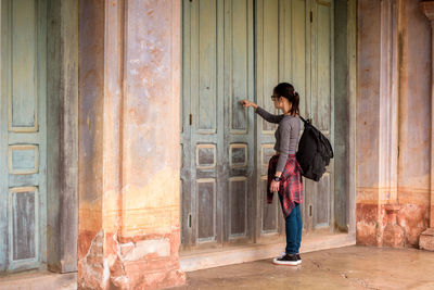 Full length of woman standing against building