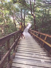 Footbridge amidst trees in forest