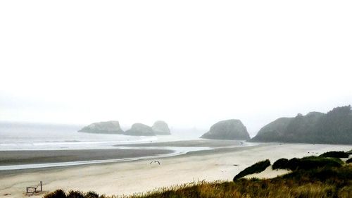 Scenic view of beach seen from cliff during foggy weather