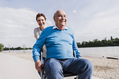 Woman pushing her old father sitting on wheeled walker