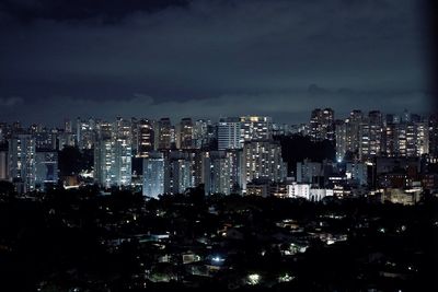 Illuminated cityscape against sky at night