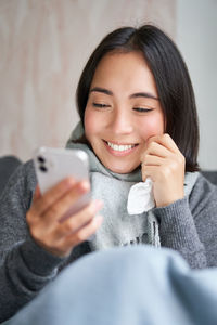 Portrait of young woman using mobile phone