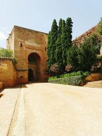 Plants by historic building against sky