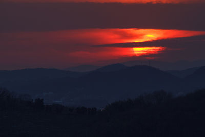 Scenic view of silhouette mountains against sky at sunset