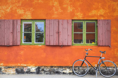 Bicycle against orange wall of building