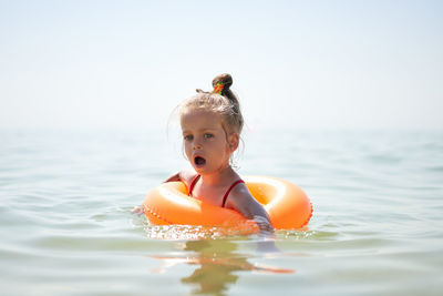 Cute girl floating in sea