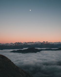 Scenic view of snowcapped mountains against sky at sunset