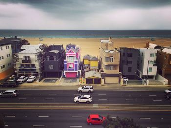 High angle view of cars moving on road by buildings