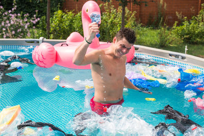 Full length of shirtless man in swimming pool