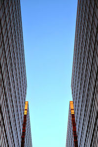 Low angle view of modern buildings against clear blue sky