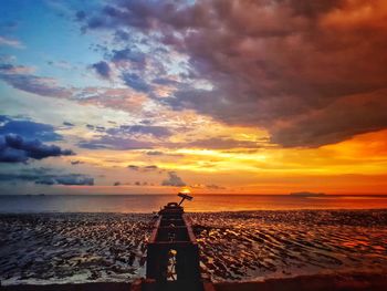 Scenic view of sea against dramatic sky during sunset