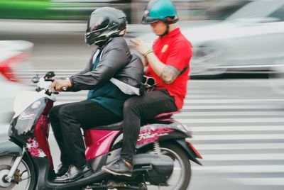 People riding motor scooter