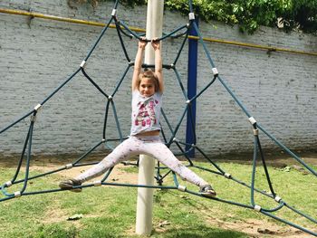 Girl standing on swing in park