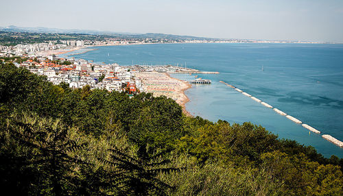 High angle view of townscape by sea against sky