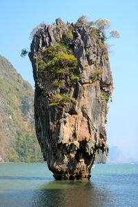 Scenic view of sea by cliff against clear sky