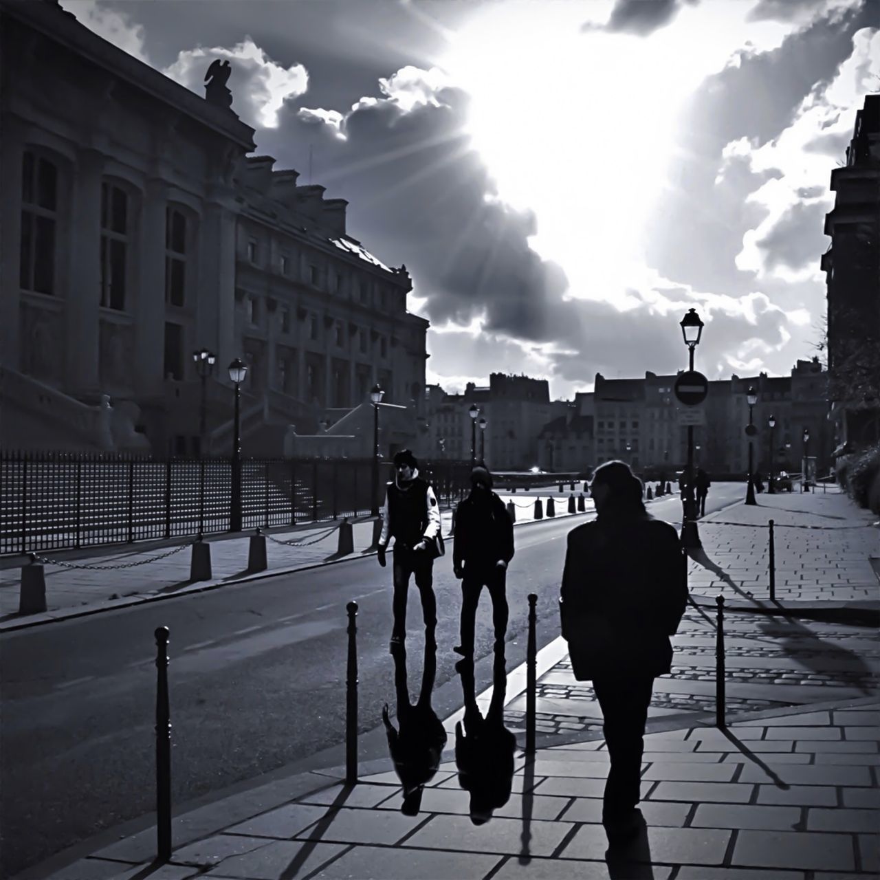 building exterior, architecture, built structure, city, men, street, walking, lifestyles, sunlight, city life, full length, person, sky, leisure activity, shadow, building, sidewalk, city street, rear view