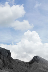 Low angle view of mountain against cloudy sky