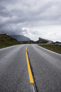 Surface level of road against cloudy sky