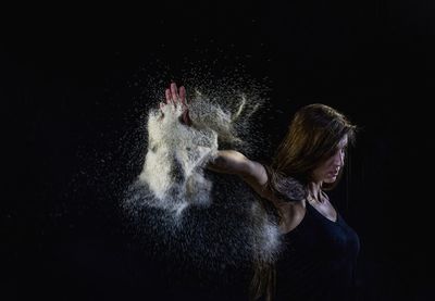 Full length of senior woman against black background