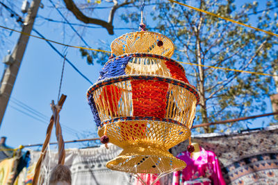 Low angle view of decoration hanging against trees