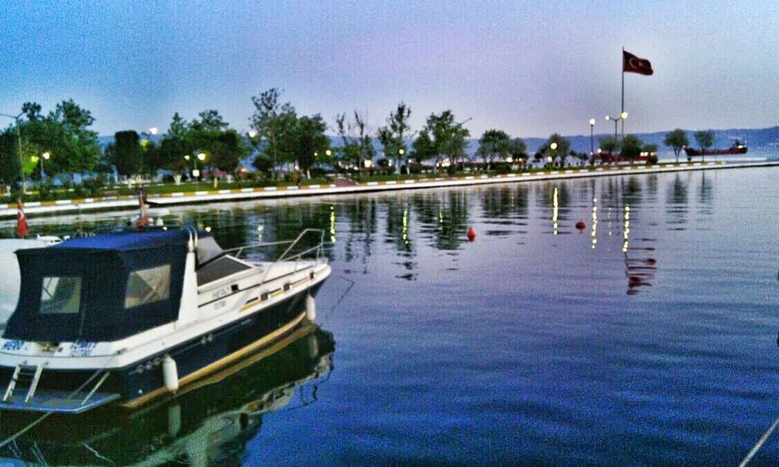 water, nautical vessel, boat, moored, sky, tree, transportation, mode of transport, reflection, waterfront, sea, tranquility, tranquil scene, palm tree, nature, lake, scenics, outdoors, blue, beauty in nature