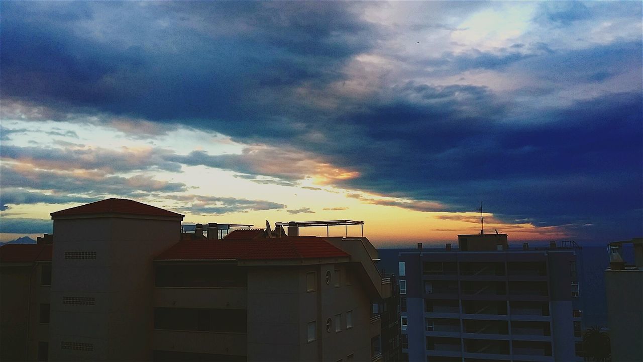 architecture, sky, built structure, cloud - sky, building exterior, cloudy, low angle view, weather, cloud, storm cloud, overcast, sunset, dramatic sky, dusk, building, house, silhouette, outdoors, no people, nature