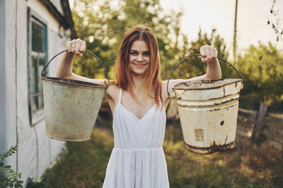 Portrait of smiling young woman holding umbrella