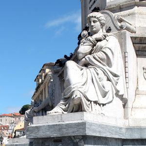 Low angle view of statue situated on the base of pedro iv monument in the rossio square, in lisbon.