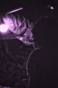 Close-up portrait of woman on illuminated lighting equipment