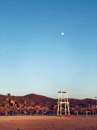 Built structure on field against clear blue sky