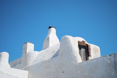 Low angle view of white building against clear blue sky in oia, santorini.