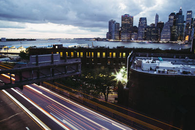 High angle view of city lit up against cloudy sky