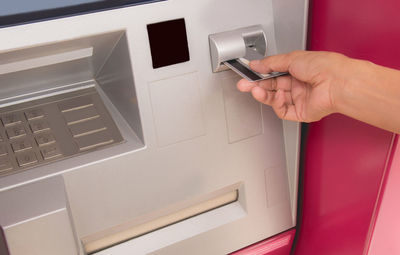 Cropped hand inserting credit card in atm