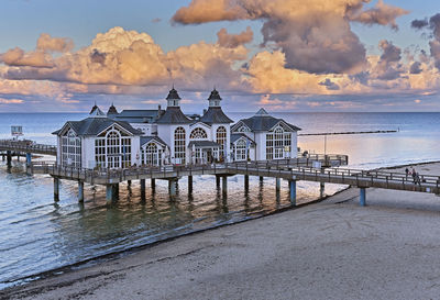 Pier by sea against sky during sunset