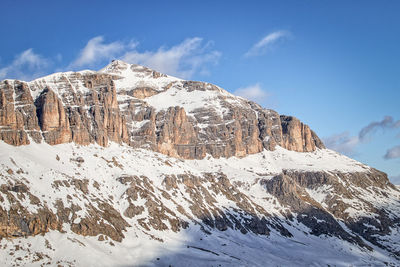 Italian dolomites mountains fassa valley gruppo sella ronda in winter with clear sky and some clouds