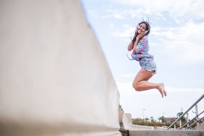 Side view of young woman against sky