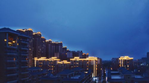 Illuminated buildings against sky at night