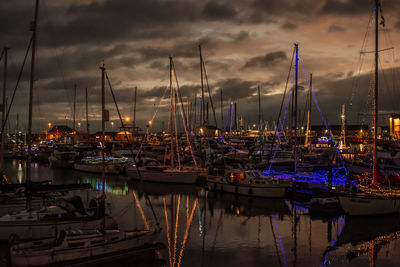 Boats moored at harbor during sunset